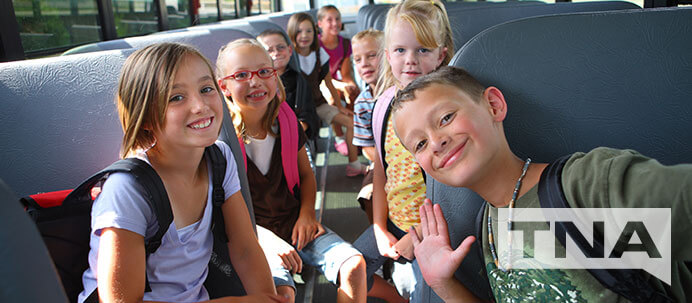 Group of children on a bus smiling