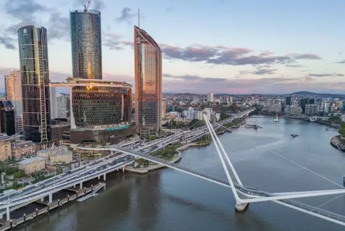 Aerial view of Queen’s Wharf Brisbane and the Neville Bonner Bridge over the Brisbane River at dusk.